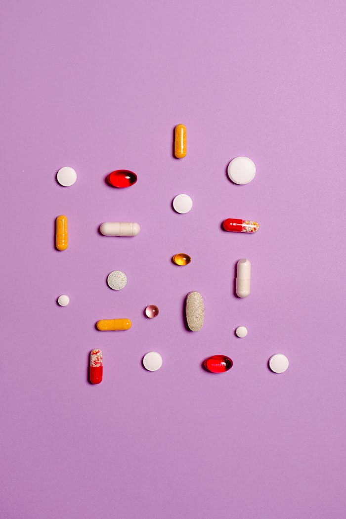 our-story Variety of pills and capsules arranged on a purple surface, showcasing different medications.